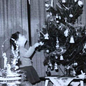 In de jaren zestig staat een klein meisje vol bewondering te kijken en naar de kerstboom vol met glanzend zilveren figuurtjes en ballen.